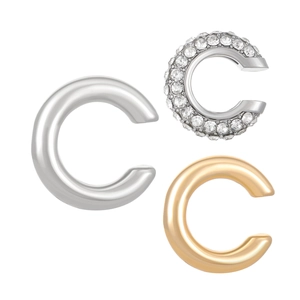 Détail de trois bagues d'oreilles en forme de C en argent et or avec zircons brillants
