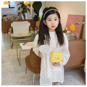 Girl model carrying a yellow mini crossbody bag with cartoon patterns and pearl handle