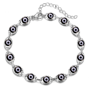 Macro view of silver evil eye bracelet featuring detailed white and black enamel beads