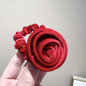 Gros plan détaillé d'un grand chouchou rose en velours rouge avec une texture de tissu doux