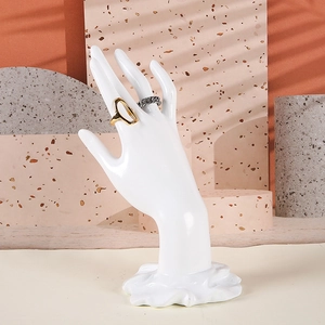 Support de bague en résine blanche montrant des bijoux sous un éclairage artistique