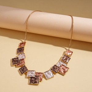 Macro view of geometric square pendant with dark brown enamel and hammer texture
