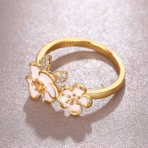 Elegant gold S925 silver ring featuring white enamel camellia flowers with crystal accents