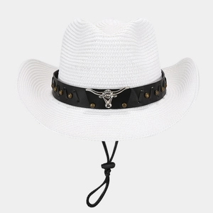 Detail of white straw cowboy hat featuring silver bull head ornament and black braided band