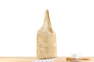 Detailed macro view of the beige paper rope woven bag with hollow mesh and fabric lining