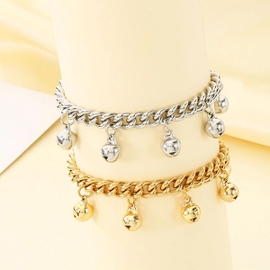 Detailed view of minimalist bell anklets in gold and silver finish on display stands