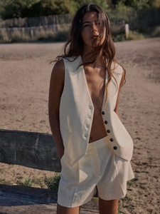 Chic beige cotton linen vest and shorts set for women in a stylish outdoor beach setting