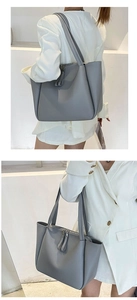 Grey matte leather tote bag detail with dual zipper closure and slim shoulder straps