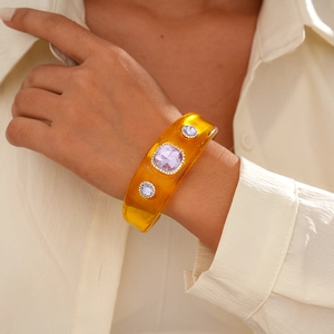Detailed view of amber resin cuff bracelet with purple gemstones and micro-pave crystals