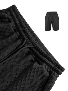 Macro detail of men's black knit shorts featuring 3D diamond texture and drawstring waist