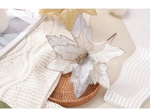 Detailed view of artificial Christmas flower with silver glitter on a cozy woven mat