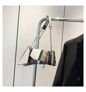 Detail of geometric patchwork shoulder bag with silver chain and pattern strap