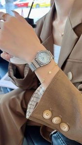 Detail of silver steel watch with zircon bezel and blue pearl dial on wrist