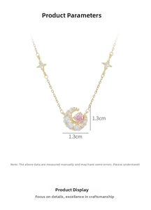 Close-up of gold moon and pink heart pendant necklace with white zircon details