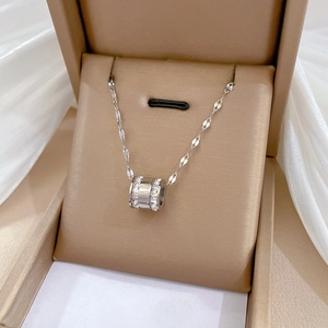 Macro shot of silver punk necklace with Roman numeral cylinder pendant in a jewelry box