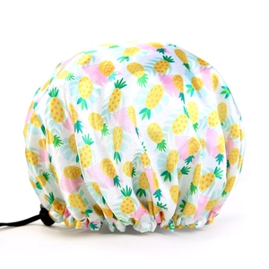 Detail of adjustable shower cap with pineapple print and secure black tightening buckle