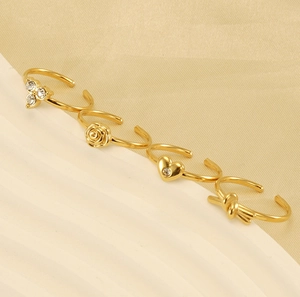 Detail view of 18K gold plated adjustable rings featuring rose, heart and clover designs