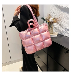 Borsa tote trapuntata rosa metallizzata portata a spalla in un ambiente moderno e chic