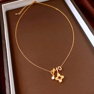 Detailed view of 18k gold plated flower pendant with clover charms and zircon accents