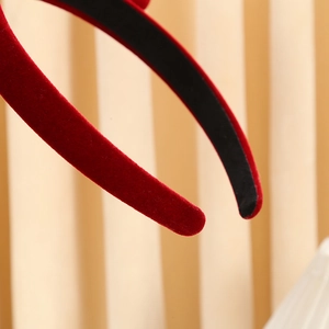 Close-up of the soft red velvet texture on the headband end with detailed stitching