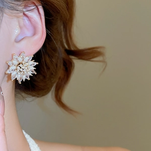 Detail of 18k gold plated flower stud earrings with marquise zircons and pearls