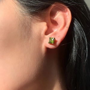 Close-up of emerald green square zircon earring with 18K gold plated prong setting