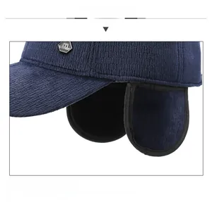 Close-up of navy corduroy baseball cap featuring thick ear flaps and a metal M logo