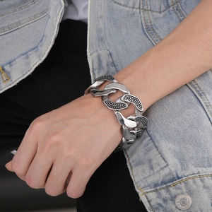 Dettaglio del grosso bracciale cubano in acciaio inossidabile con trama a pois da uomo