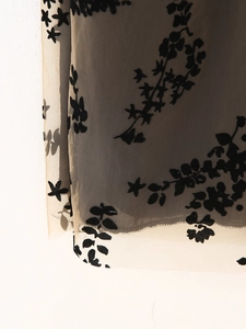 Détail de la robe sexy en résille avec motif floral floqué noir et tissu dévoré