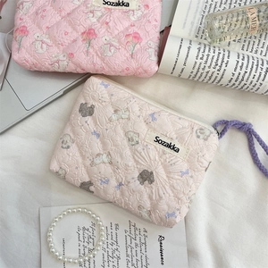 Close-up of floral quilted pouches with cute rabbit and bear patterns and zipper detail