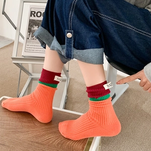 Street style orange ribbed crew socks with color blocks and small fabric label