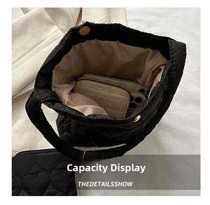 Internal view showing spacious capacity for phone and wallet in black quilted tote bag