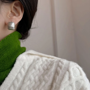 Minimalist silver square hoop earrings with textured finish worn by a fashion model