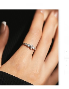 Macro view of dainty S925 sterling silver ring featuring five sparkling cubic zirconia stones