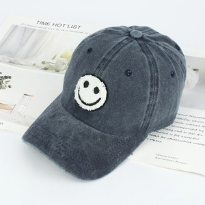 Close-up of chenille smile patch on vintage washed grey cotton baseball cap