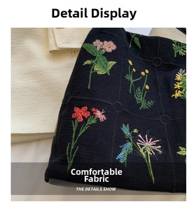 Close-up of vibrant floral embroidery details on black canvas bucket bag texture