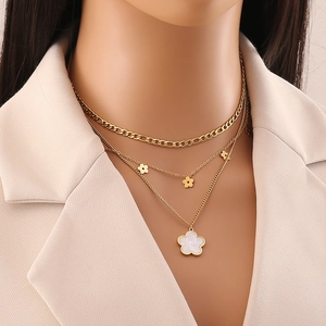 Detail view of triple-layered gold stainless steel necklace with shell flower pendants