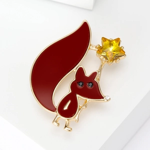 Cute red fox brooch with a yellow crystal star and golden metal edges on white background