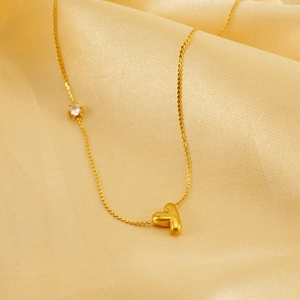 Close-up of golden letter Y puffy pendant necklace with zircon inlay on silk background