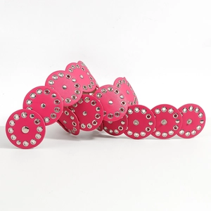 Close-up of hot pink leather disc belt with silver metal rivet studs and punk style texture