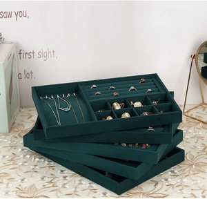 Deep green velvet jewelry organizer trays stacked to show layered storage capacity