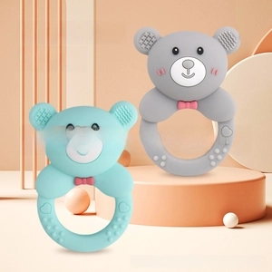 Close-up of bear-shaped silicone baby teethers with textured massage bumps in grey and teal