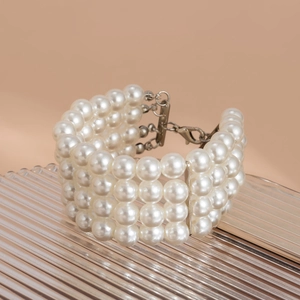 Detail of four-row layered faux pearl bracelet with silver lobster clasp and metal bars