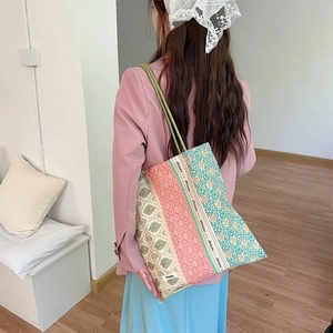 Détail du sac cabas en toile à patchwork floral avec étiquette Sozakka sur la bandoulière