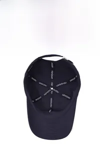 Detail view of adjustable metal buckle and breathable stitching inside navy baseball cap