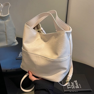 Chic beige pleated bucket bag with wide handle and thin shoulder strap for women