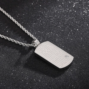 Vue macro du pendentif rectangulaire argenté avec le Notre Père gravé et diamant