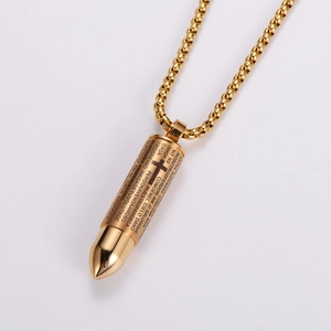 Detailed macro shot of golden bullet pendant with Spanish Lord's Prayer and cross engraving