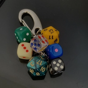 Detail of trendy keychain featuring colorful multi-sided resin dice and metal hook