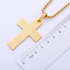 Close-up of gold-plated cross pendant with Spanish Lord's Prayer engraving and ruler measurement